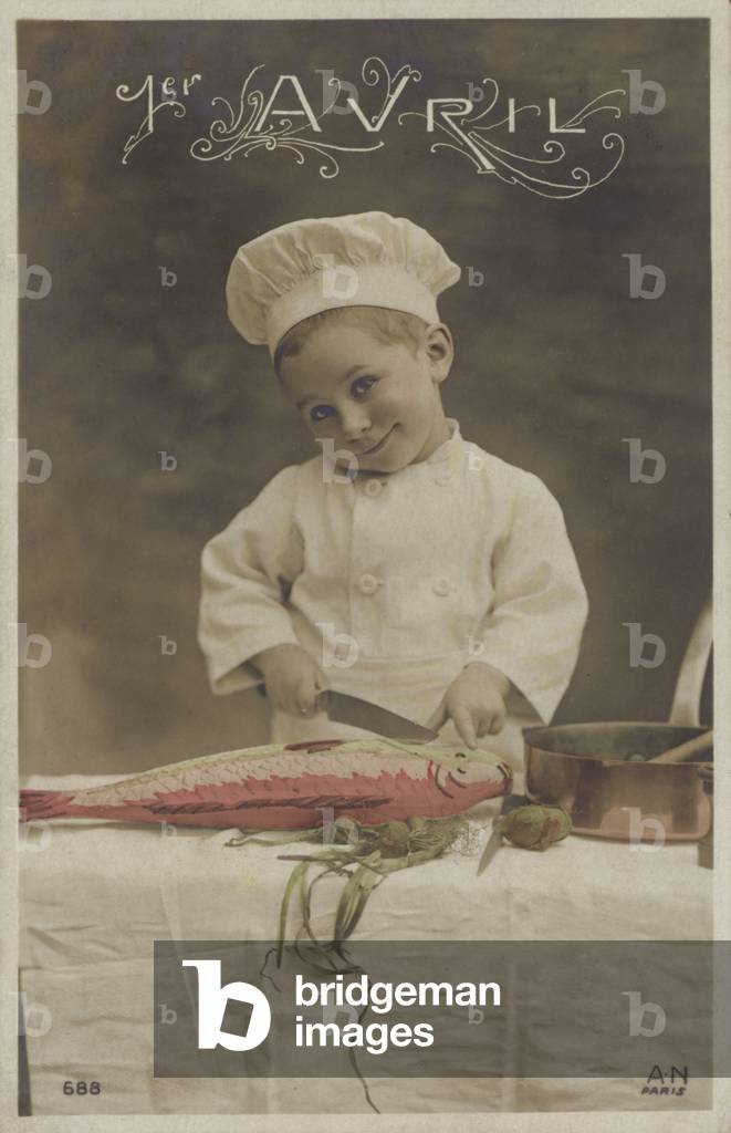 Little boy cooking a fish (colour photo)