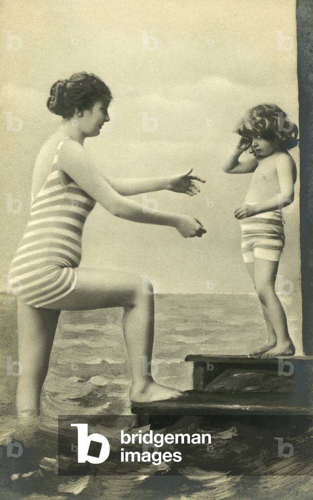 Woman reaches to pick up her child (b/w photo)