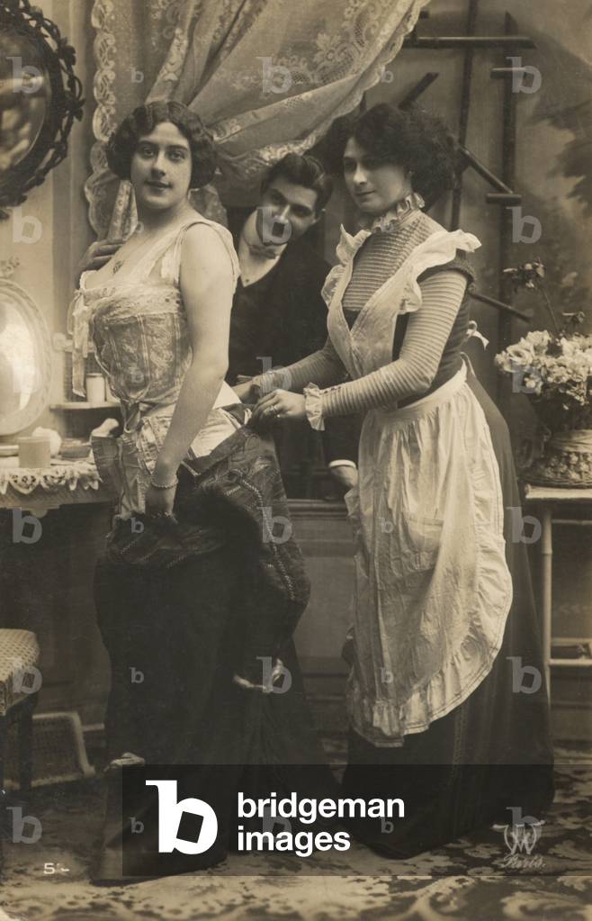 Man watching a woman dress (b/w photo)