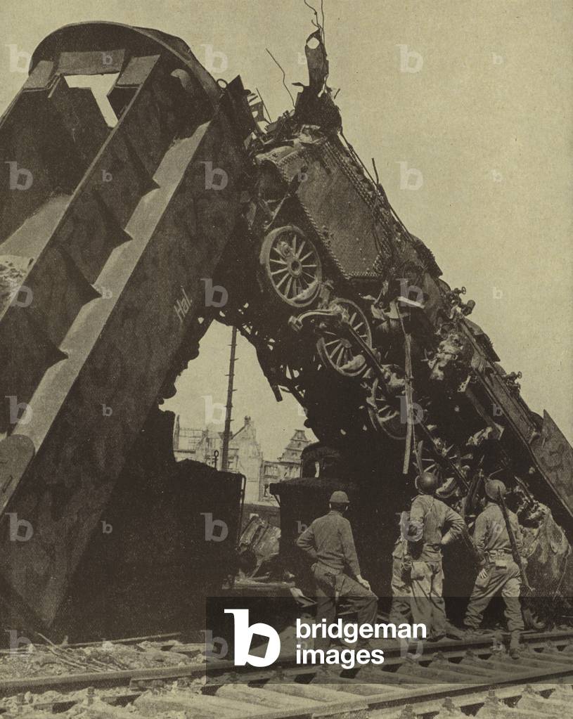 American soldiers looking at a steam locomotive hit by an allied bombing raid on Munster, Germany, World War II, 1945 (b/w photo)