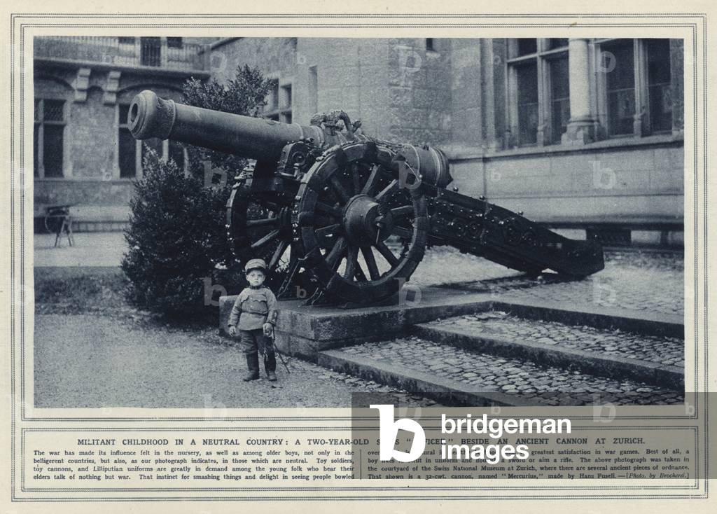 Militant childhood in a neutral country, a two-year-old Swiss officer beside an ancient cannon at Zurich (b/w photo)