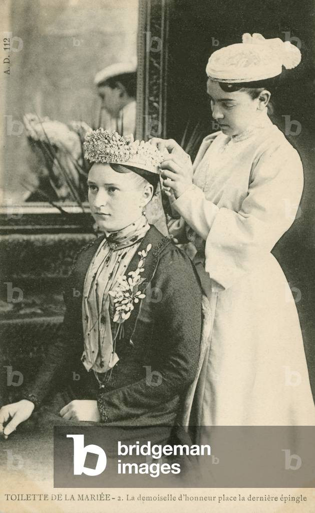 Bride trying on her veil (b/w photo)