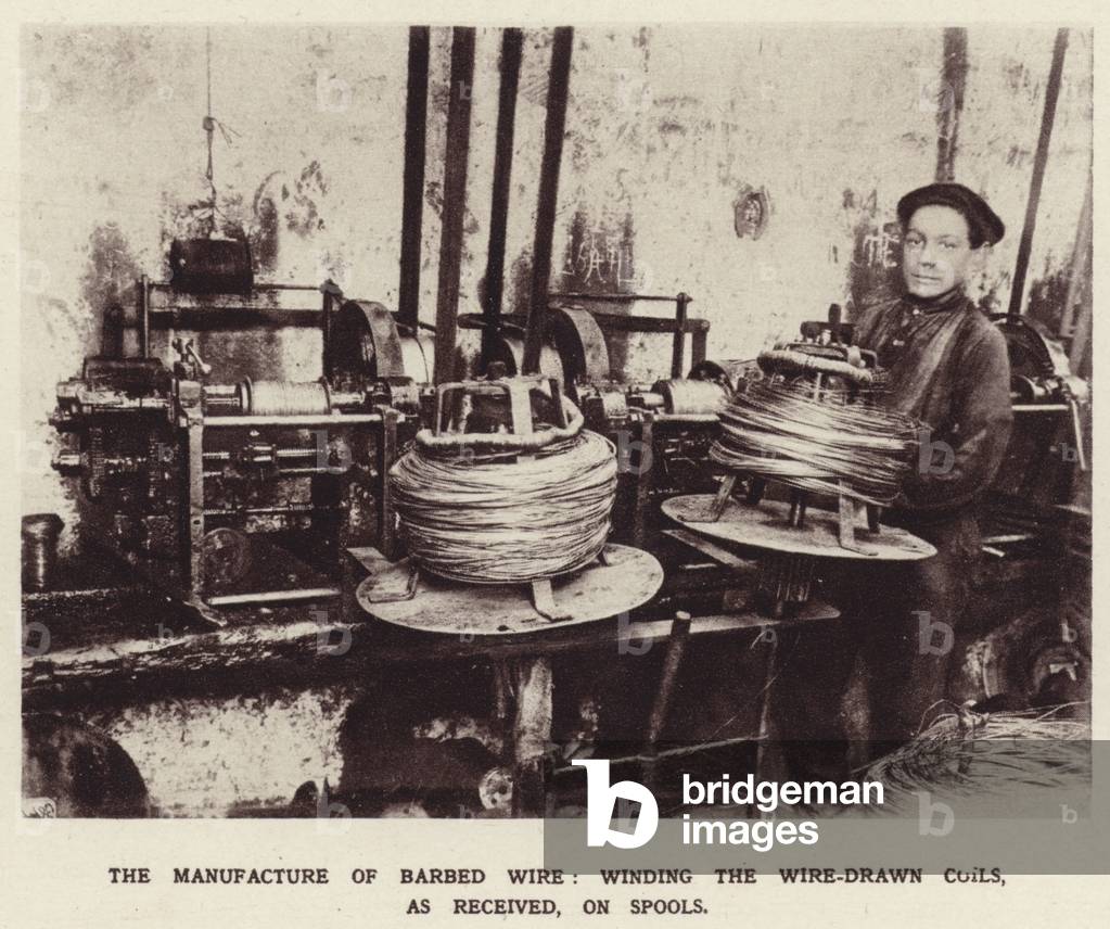 The manufacture of barbed wire, winding the wire-drawn coils, as received, on spools (b/w photo)