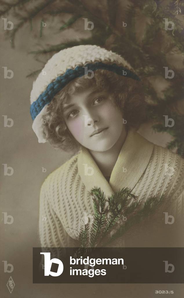Pretty girl, in woolen hat and sweater, holding a piece of fir (photo)
