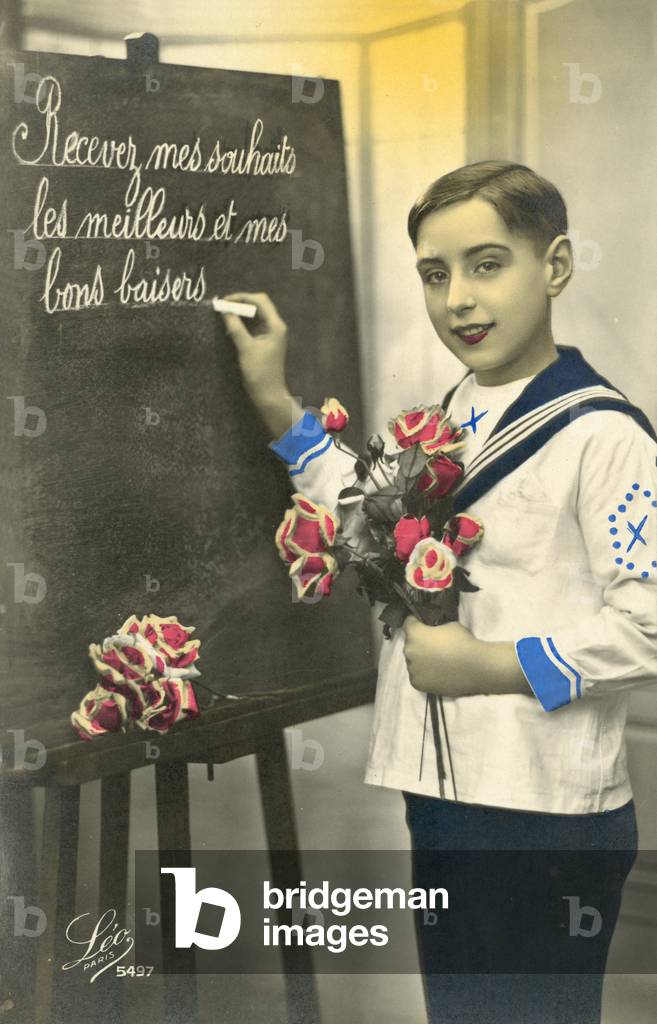 Schoolboy writing on a blackboard (colour photo)