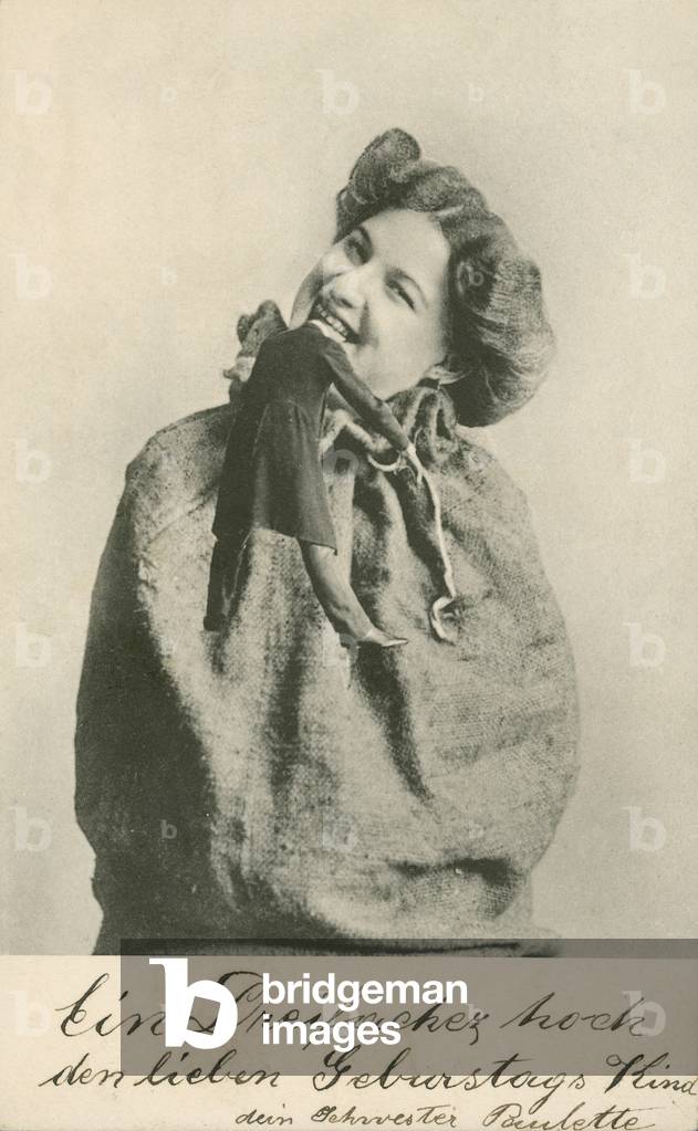 Woman biting the head off a doll (b/w photo)