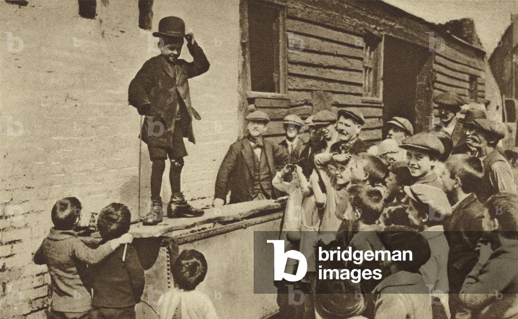 A budding humorist of the East End doing a Charlie Chaplin impression (b/w photo)