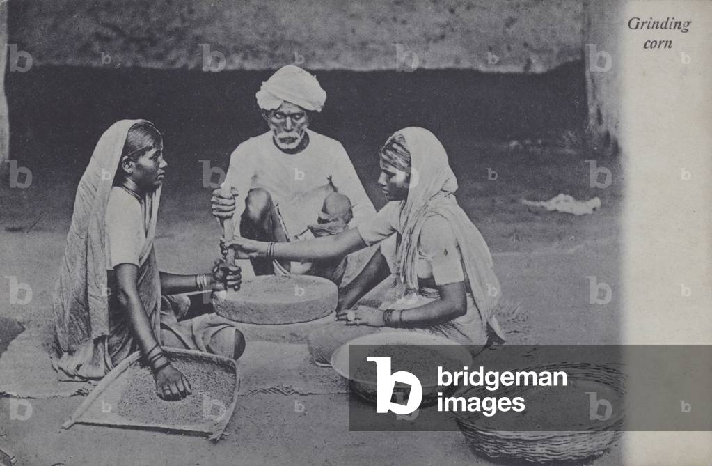 Man and women grinding corn, North Africa (b/w photo)