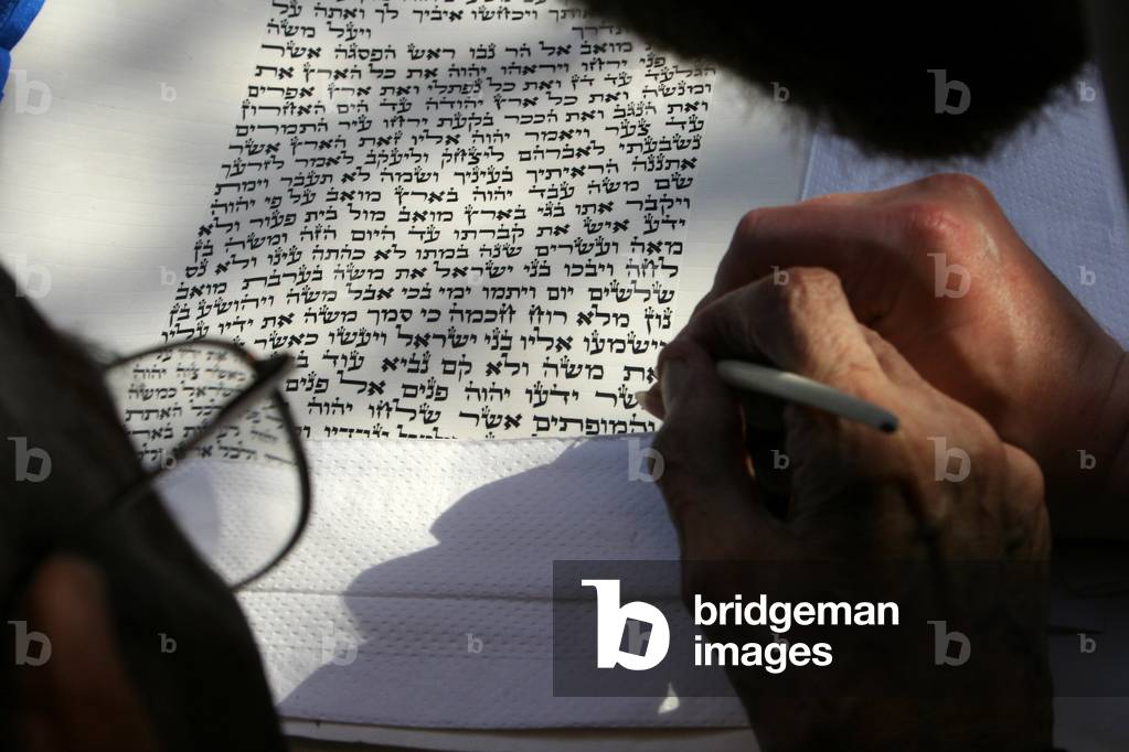 Scribe completes the final letters of a Torah scroll