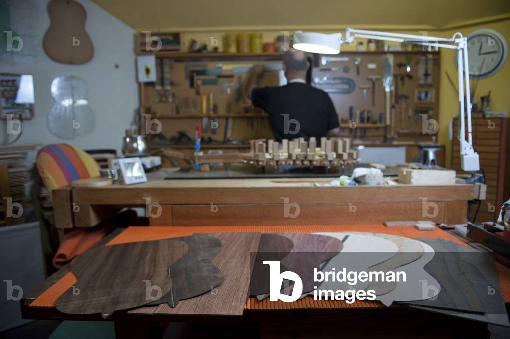 Master Luthier (Guitar-Maker) in his workshop in the process of making a classical Spanish guitar