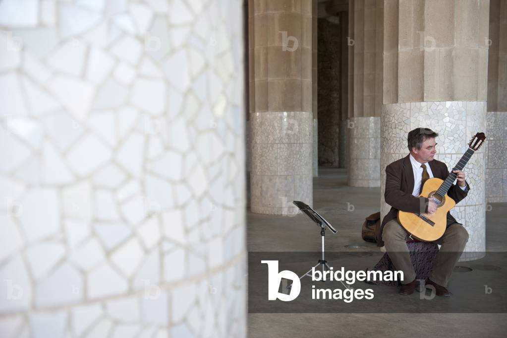 Musician playing guitar in the Güell park, Barcelona, Catalonia, Spain