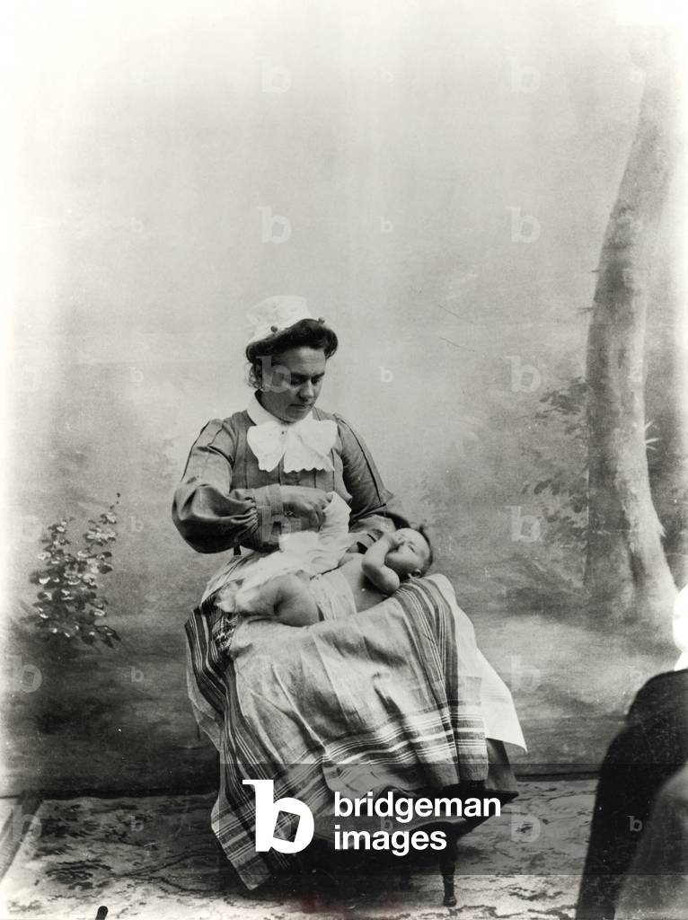 Nanny showing how to dress a baby, c.1900-05 (b/w photo)