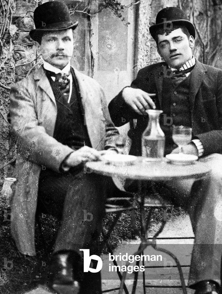 A chatelain (Ducos) and his coachman sitting on the terrace of a café and drinking absinthe - photograph, circa 1890