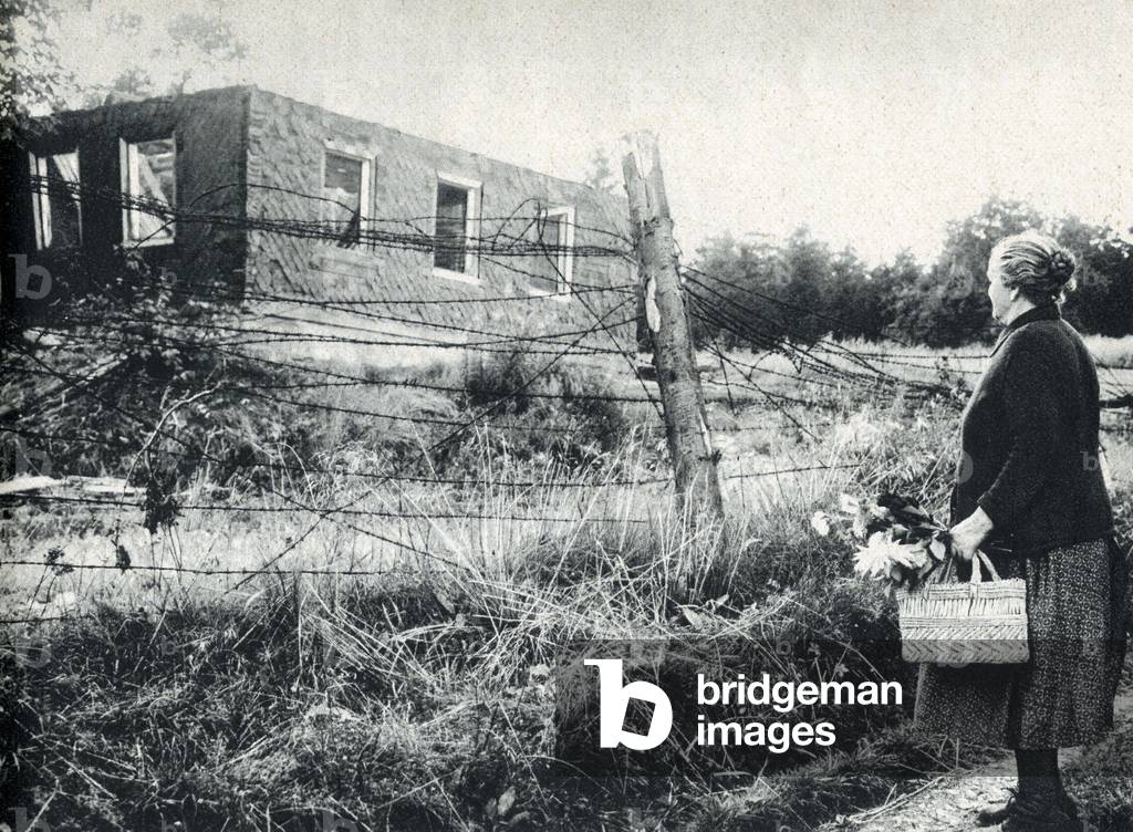 Woman separated from her house by the iron curtain (barbele wire) built in 1961 between the Federal Republic of Germany (FRG) and the Democratic Republic of Germany (GDR). Photography, Berlin, 1961.