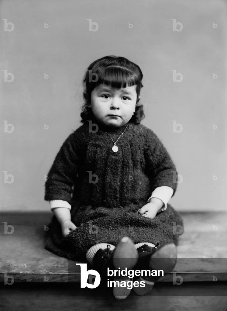 Portrait of a little girl from Bourmont in Haute Marne, with her baptism medal. Photography late 19th century. Ducos Collection.