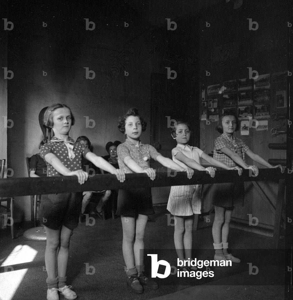 France: Gym, four young girls pose in front of the beam, 1935