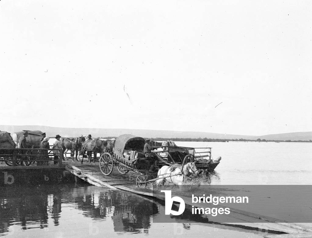 Russia: A ferry crosses a river, arrives, unloading the ferry, 1900