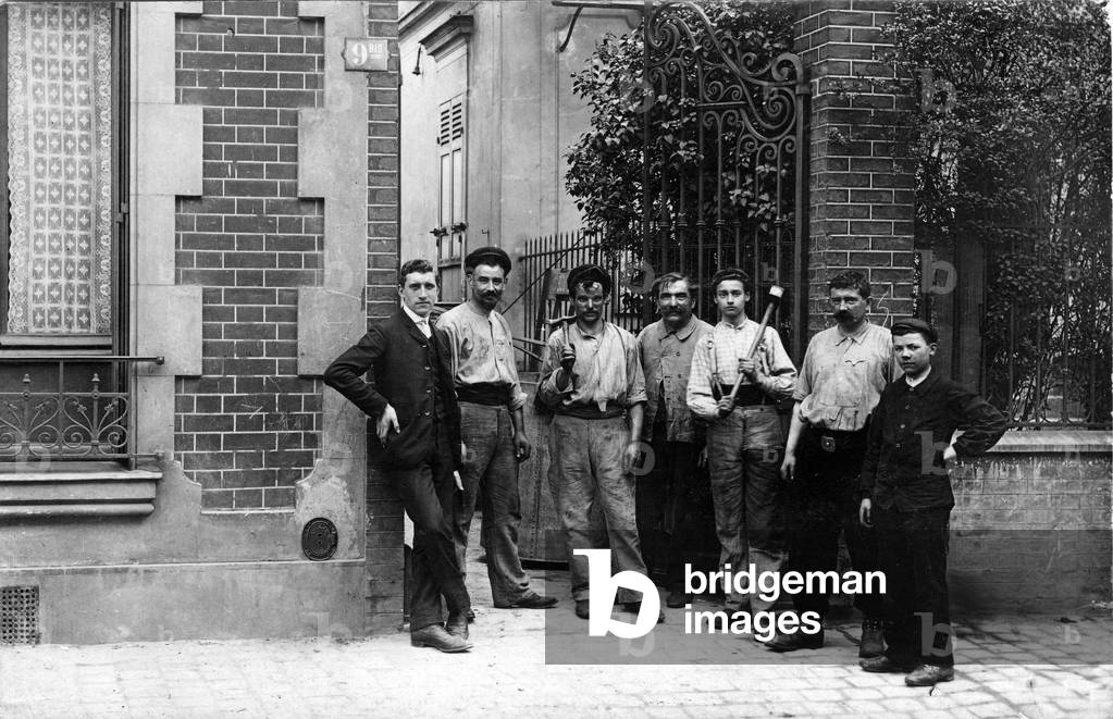 France, Ile-de-France, Paris (75): A young boss and his workers pose at the door of a workshop with their tools, 1910