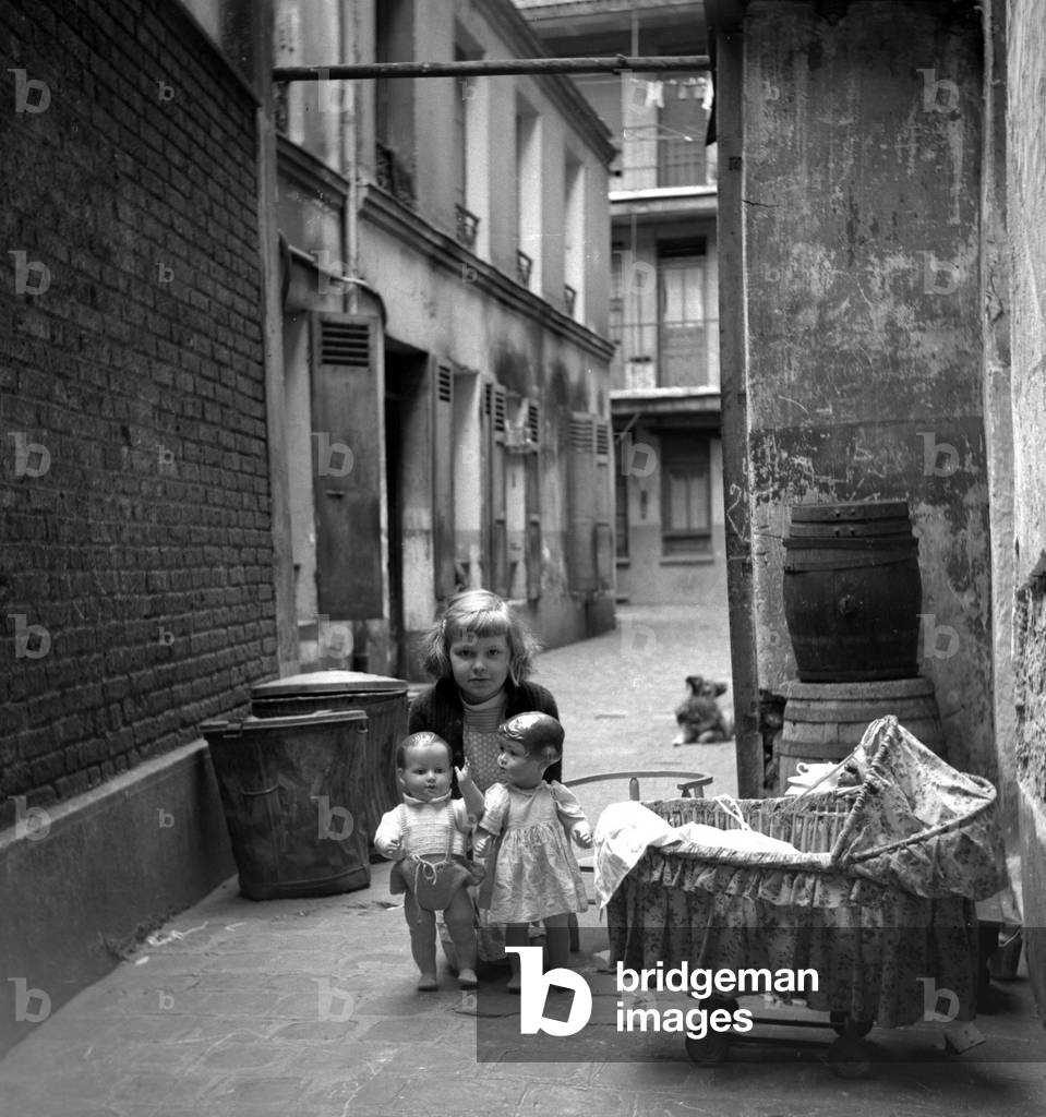 France, Ile-de-France, Paris (75): in a building course, a little girl plays with her two dolls, 1945