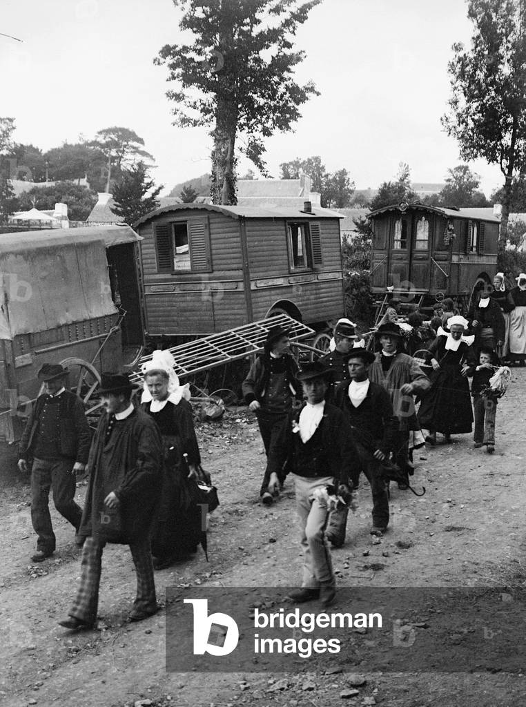 France, Brittany, Finistere (29), Rumengol: May 1908, the forgiveness of the Trinite Our Lady of all Remedy, the pelerins in local clothes, men in hat and blouse, women in headdresses pass by the trailers of gypsies