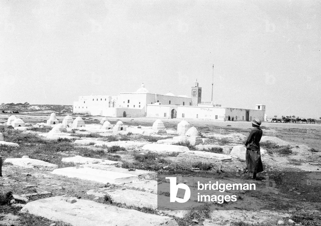 Egypt: European woman contemplates Arab village and cemetery, 1930