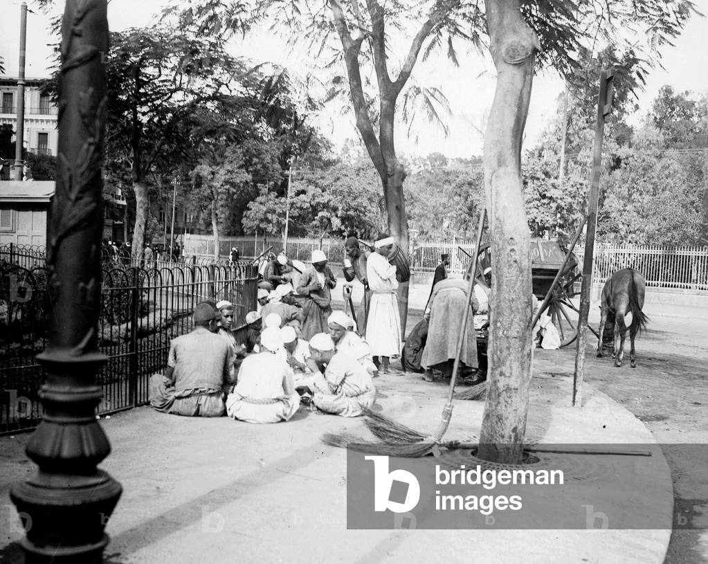Egypt, Cairo: Cook cruise, Nile side, sweepers sitting on the sidewalk smoke the shisha, 1900