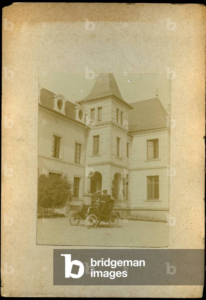 France: In the courtyard of a Chateau a driver waits for his passenger in a car, 1890