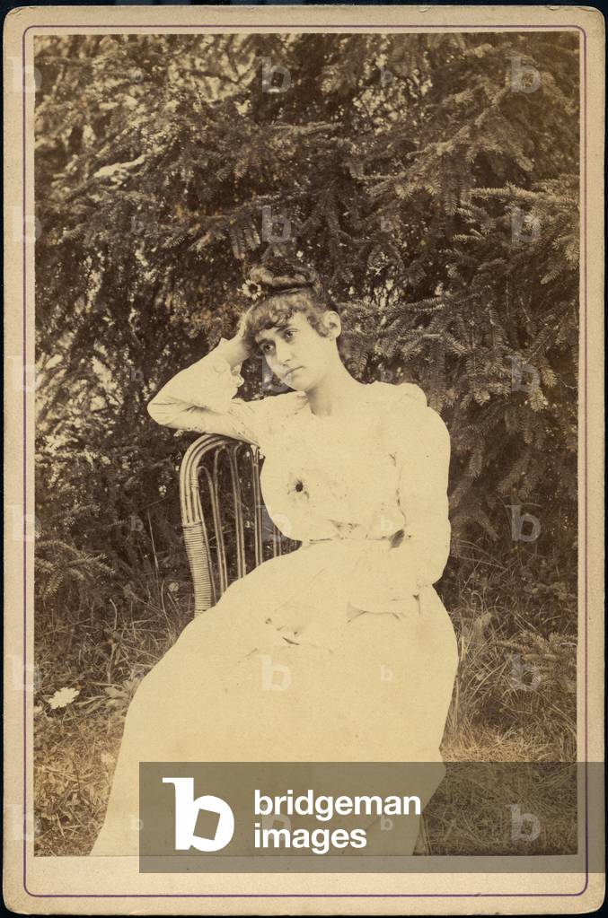 Romantic portrait of a girl posing in her garden with flowers, 1885