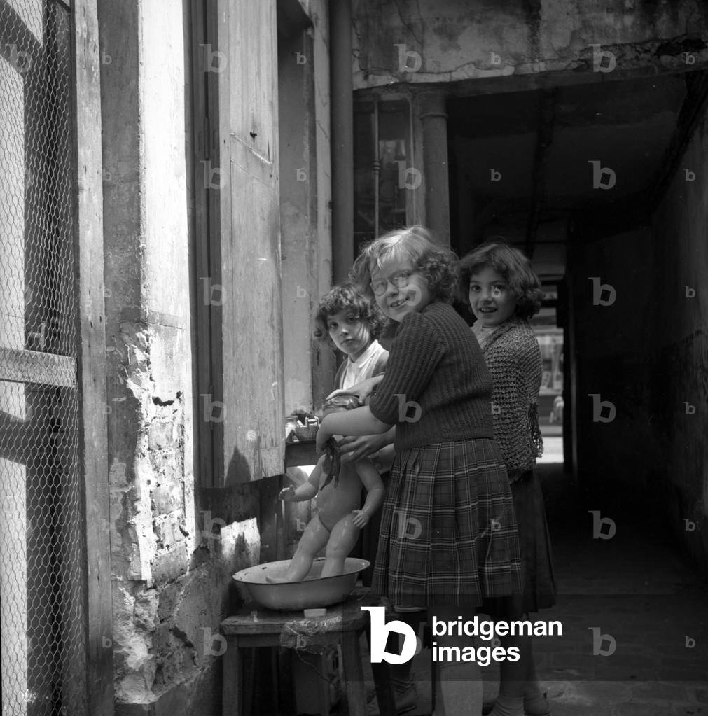 France, Ile-de-France, Paris (75): in a building yard three little girls wash their bathers, 1945