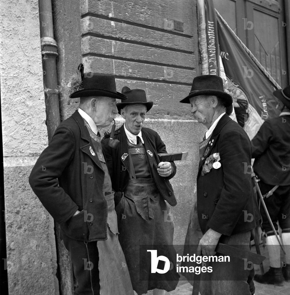 Tyrol, Innsbruck: Old loggers in traditional dress with badge and medals discuss, 1937