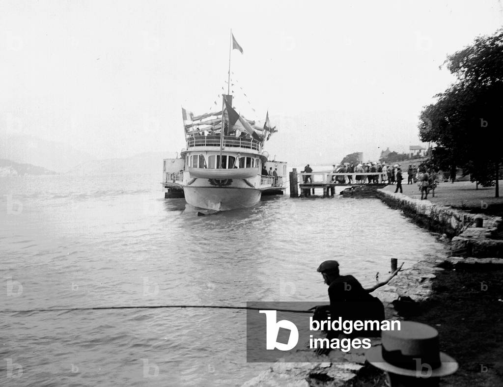 France, Rhone-Alpes, Haute-Savoie (74), Talloires: Lake Annecy. The boat 'France' has dock and a fisherman in the foreground, 1900 - Boat: France