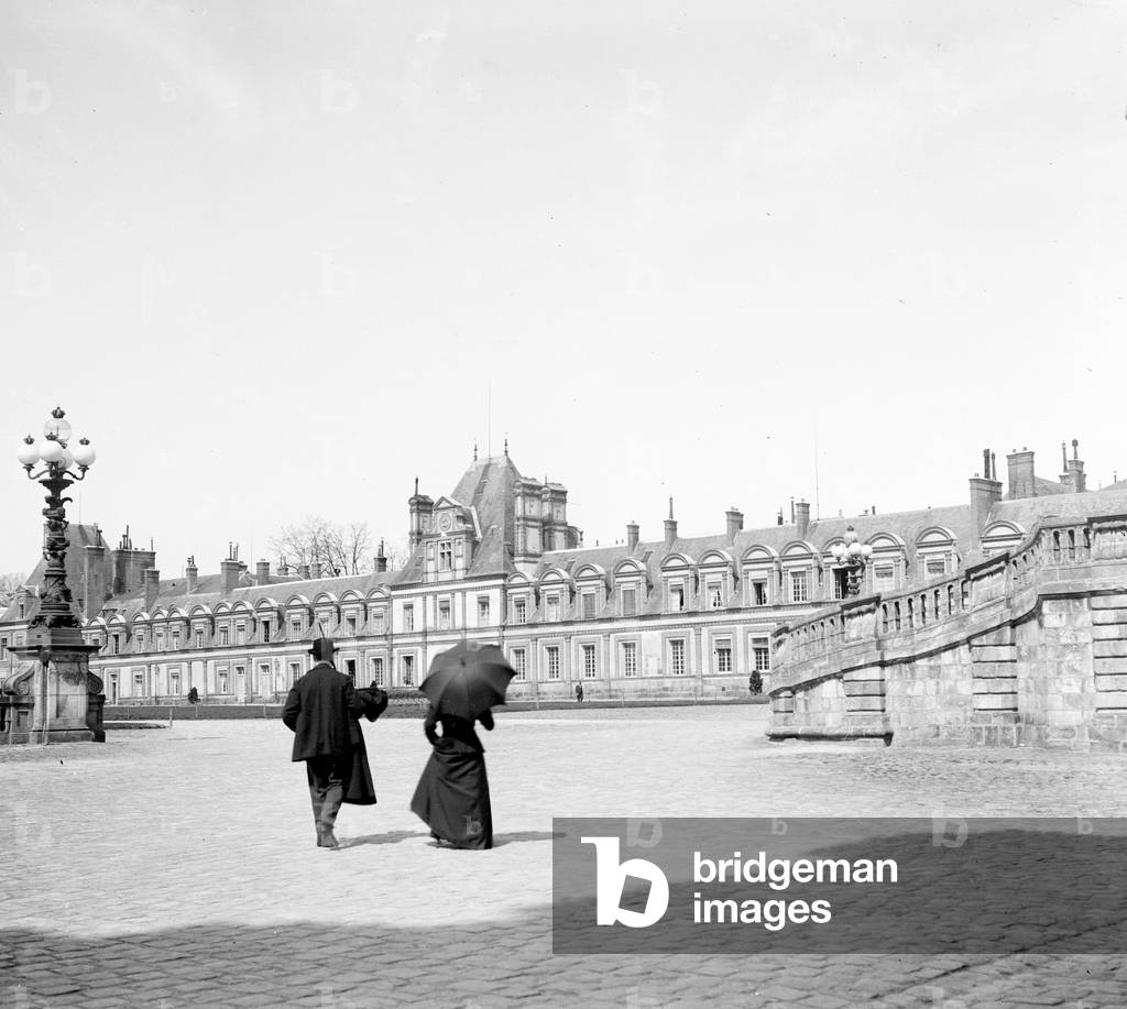 France, Ile-de-France, Seine-et-Marne (77), Fontainebleau: 15 April 1900, Courtyard du cheval blanc with couple tourists, 1900