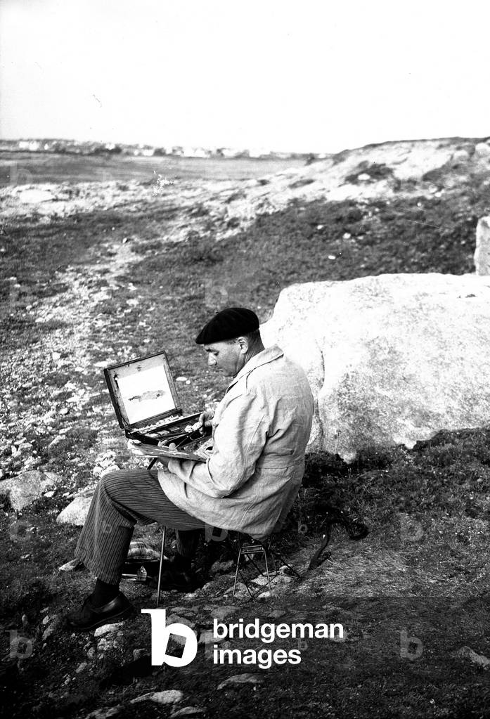 France, Brittany, Ille-et-Vilaine (35): Sunday painter with his box of watercolours sitting on a folding painting a marine landscape, 1935
