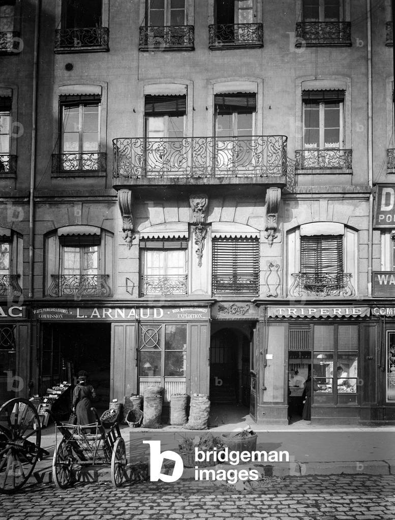 France, Rhone-Alpes, Rhone (69), Lyon: Saint Paul/Saint Jean neighborhood, Quai de Bondy, 18th building with balconies of wrought iron - A tripier at work in front of his shop, 1900 - shops: tobacco L Arnaud early fruits vegetables commisssions and walnuts orange expeditions
