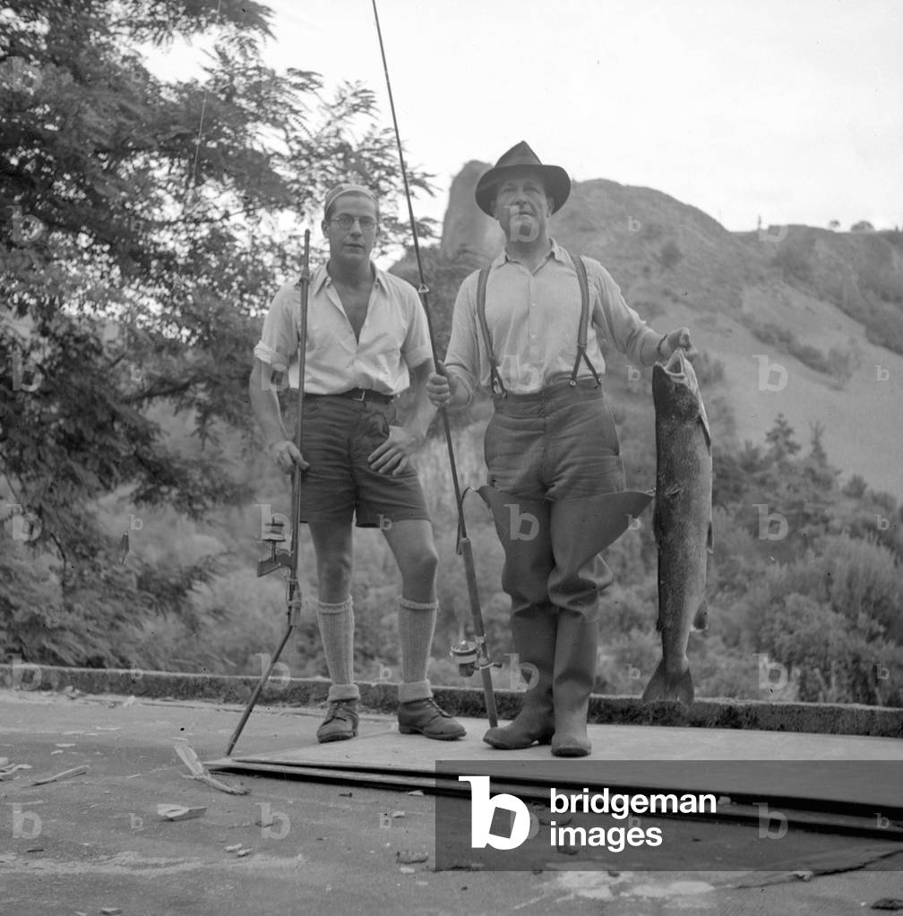 Two men show the fish they just fished, 1947