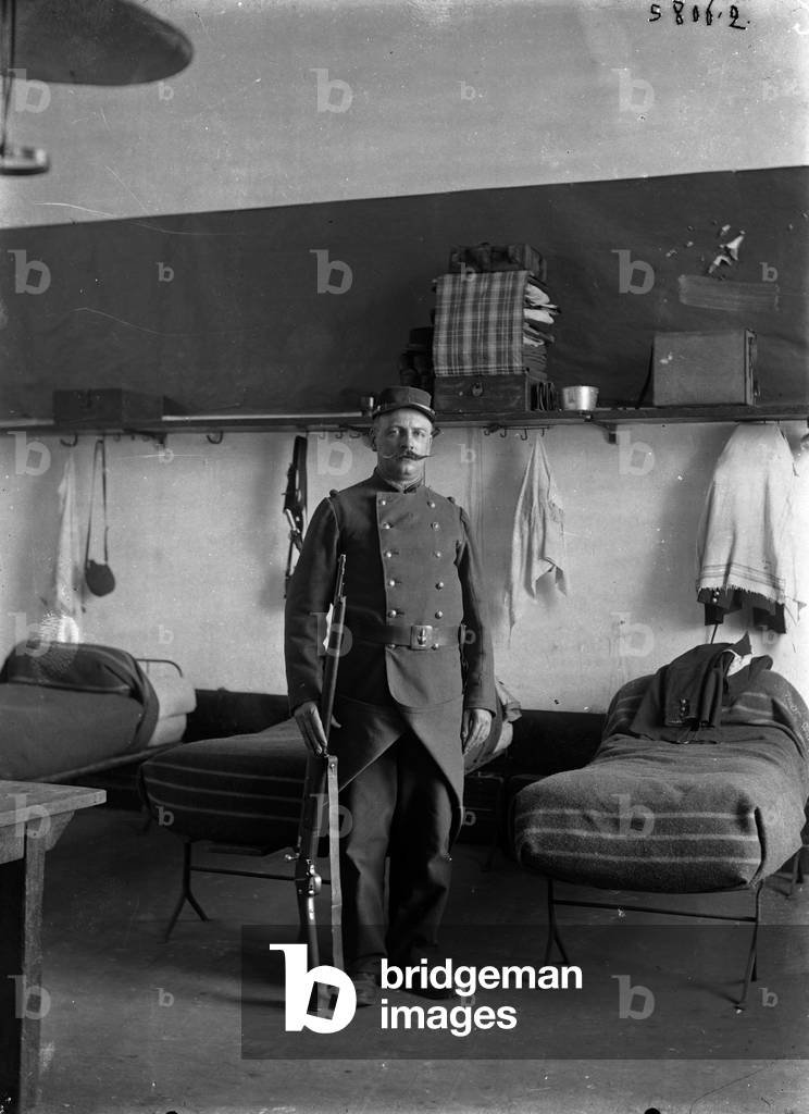 France, Ile-de-France, Paris (75): portrait of a soldier of the 2nd regiment in uniform at the barracks, at the guard at you in front of his bed, 1900