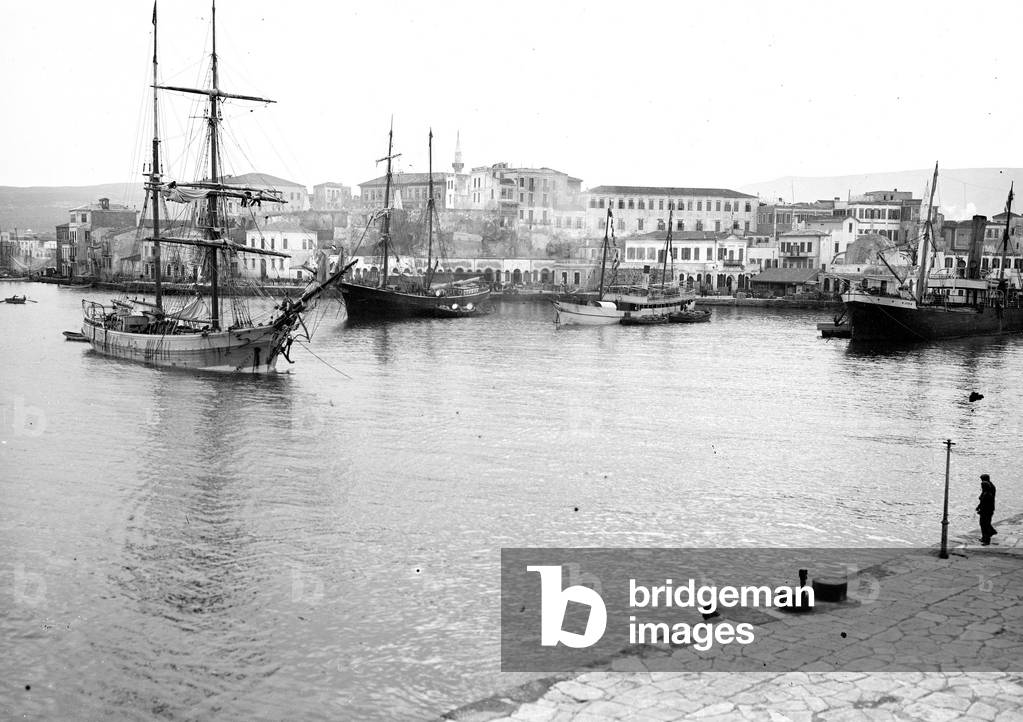 Greece, Chania, CR: The port with sailing boats and steamboat. Active port, barrel cargo on wharf, 1906