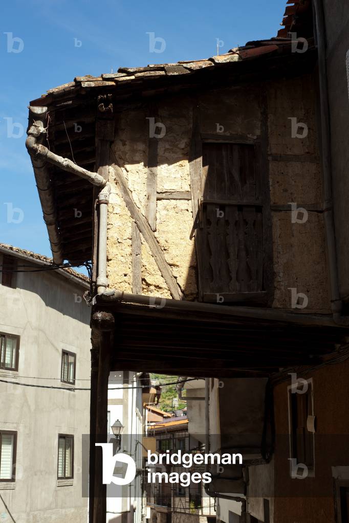 A street view. Detail of a house façade. Timber work. A gallery.