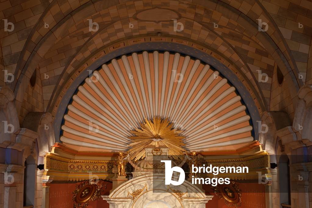 El santuari de la Mare de Dèu del Pla. interior de l'Església. Església de Nostra Senyora del Pla s. XVIII Part superior del cambril amb rajos daurats i en el centre d’una petxina flanquejada per dos àngels. Fins fa poc de l’àngel de l’esquerra hi penjava un tros de corda, record de l’any 1936, en que el van voler tirar a terra i la corda es va trencar.