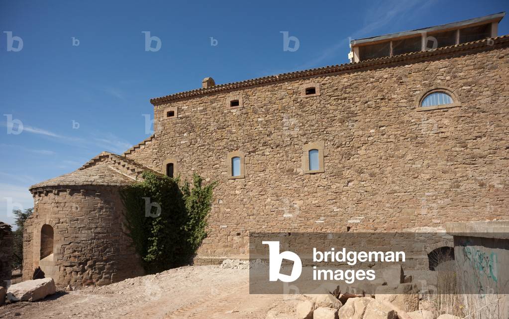 Parish church (Església Santa Maria del Castell de Cubells). Exterior. The chevet and the castle. Romanesque.