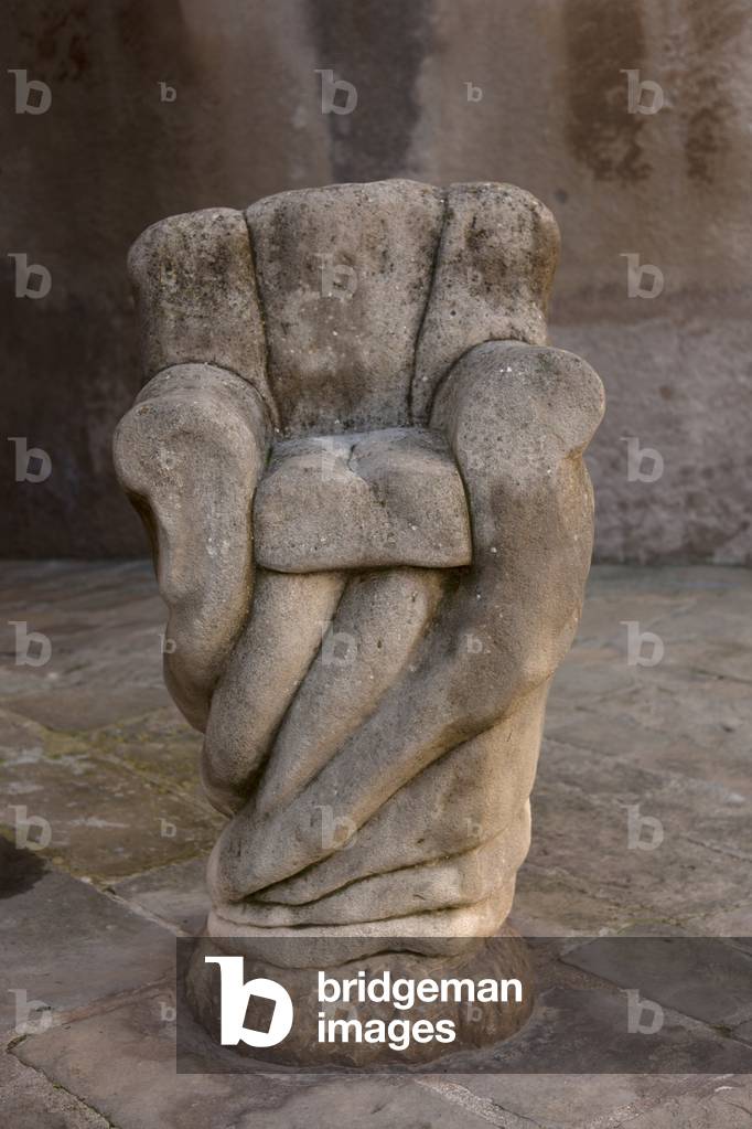 A public sculpture of a seat. Stone.