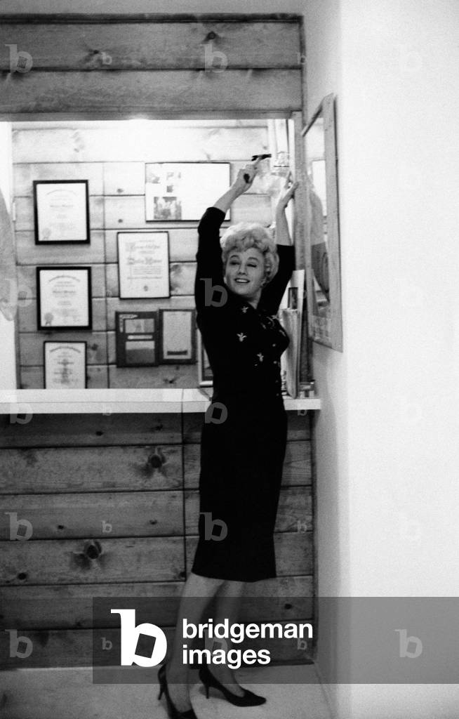 Shelley Winters hangs up a painting