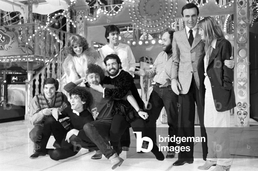 Italian TV host Pippo Baudo posing with the cast of the TV show Luna Park, Italy, 1979 (b/w photo)