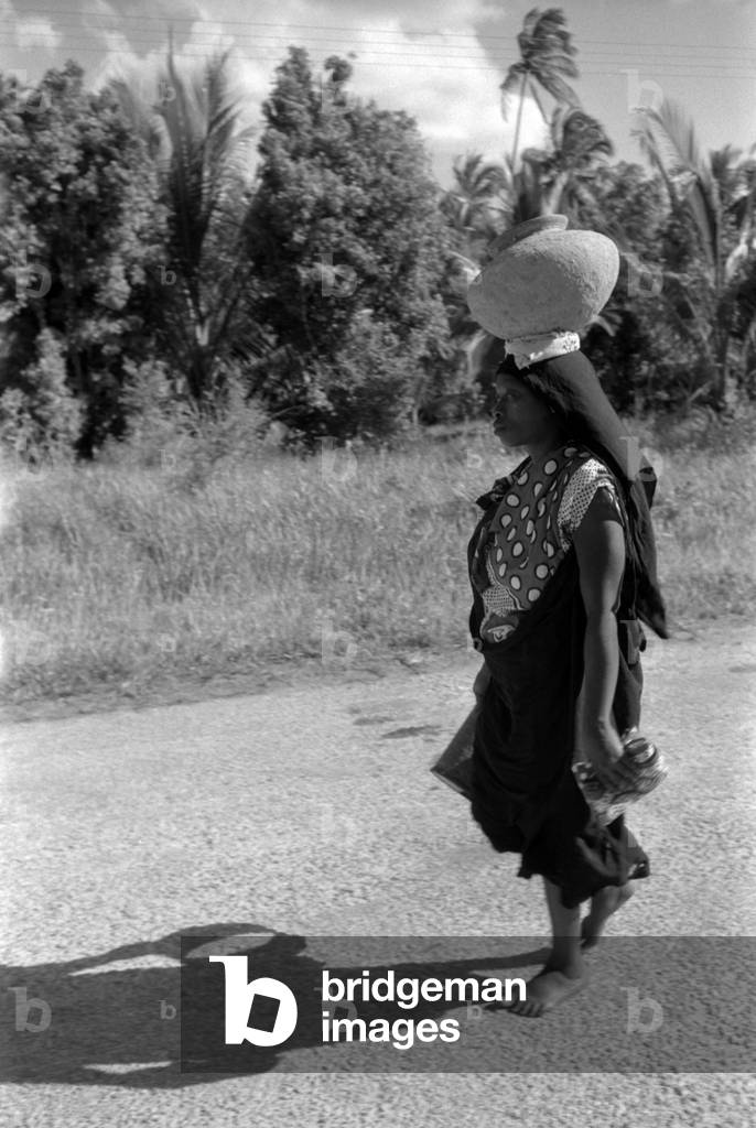 African woman walking with a jar on the head, Zanzibar, October 1958 (b/w photo)