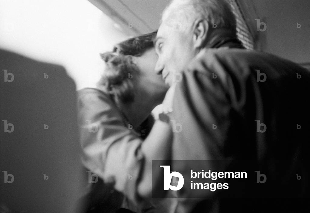 A woman kissing a man