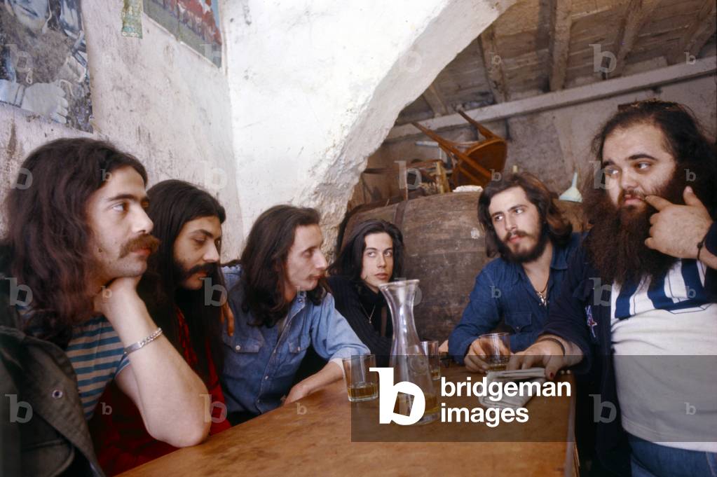 The rock band Banco del Mutuo Soccorso seated around a table