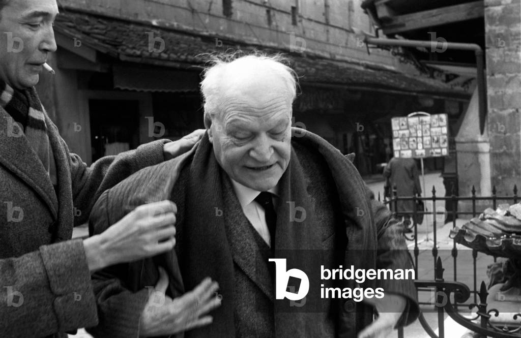 A man helps Giuseppe Ungaretti to take off his coat