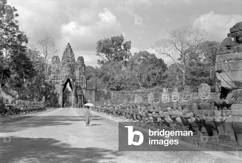 The giants supporting a long snake at the entrance of the city of Angkor Thom, Angkor Thom, Cambodia, 1960s (b/w photo)