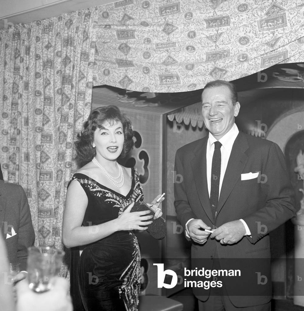 John Wayne and Pilar Pallete smiling (b/w photo)