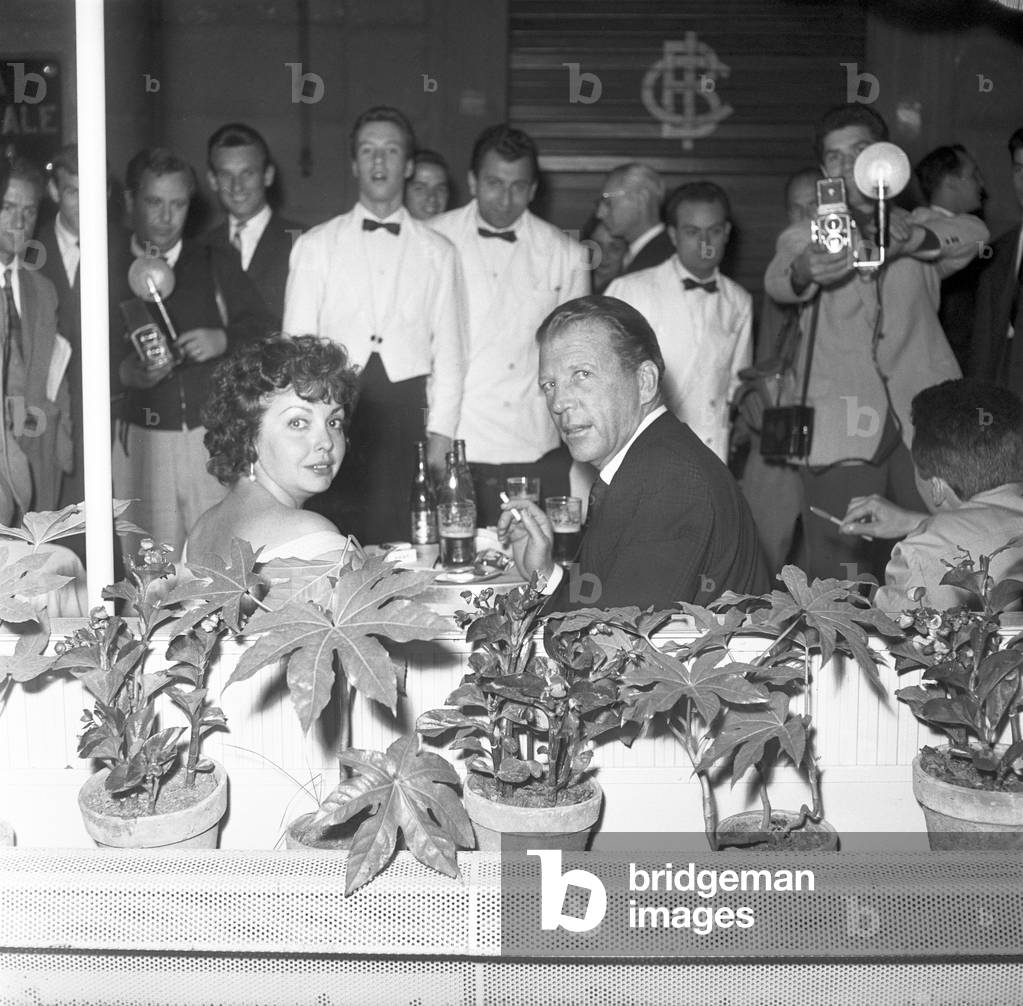 Dan Dailey with Camilla Williams at a bar in Via Veneto, Rome, Italy, 1959 (b/w photo)